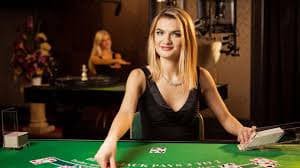 Mobile phone showing desk gaming live casino lobby with baccarat and roulette tables